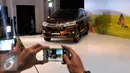 Pengunjung mengabadikan acara Launching Daihatsu Great New Xenia, Jakarta, Rabu (12/8/2015). Great New Xenia merupakan generasi ke tiga dari Dahaitsu Xenia dengan tiga kelebihan utama yaitu, lebih stylish, efisien dan bertenaga. (Liputan6.com/Johan Tallo)