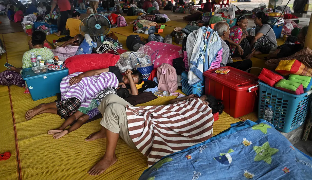 Warga yang mengungsi akibat konflik antara Thailand dan Kamboja beristirahat di pusat evakuasi sementara di dalam sebuah kuil Buddha di provinsi perbatasan Thailand, Si Sa Ket, pada 26 Juli 2025. (Lillian SUWANRUMPHA/AFP)