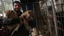 Pemilik kebun binatang, Ahmad Jumaa menggendong satu dari tiga anak singa berusia dua bulan yang akan dijual di Jalur Gaza, 22 Desember 2017. Hasil penjualan anak singa itu akan digunakan membiayai singa lain yang ada di kebun binatangnya. (AP/Adel Hana)