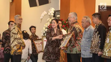 Menko PMK, Puan Maharani memberikan penghargaan Prestasi Penyelenggaraan Lebaran 2017 kepada Menteri Perdagangan, Enggartiasto Lukita di Jakarta, Selasa (1/8). UKP-PIP memberi penghargaan kepada 15 instansi pemerintah. (Liputan6.com/Faizal Fanani)