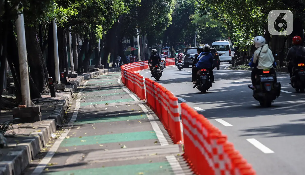 Kendaraan melintasi "stick cone" pembatas jalur sepeda di kawasan Pejompongan, Jakarta, Selasa (29/11/2022). Pemprov DKI Jakarta kembali mengganggarkan dana untuk perawatan jalur dan evaluasi pembatas sepeda pada rancangan APBD tahun anggaran 2023 sebesar Rp7,5 miliar setelah sebelumnya sempat dicoret dari anggaran dan menuai kecaman dari sejumlah pihak. (Liputan6.com/Johan Tallo)