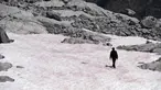 Gambar pada 4 Juli 2020 di gletser Presena dekat Pellizzano, Italia menunjukkan seorang pria berjalan di atas salju berwarna pink atau merah muda. Perubahan warna ini diketahui karena adanya tumbuhan alga di kawasan itu yang membuat warna salju menjadi lebih gelap. (Photo by Miguel MEDINA / AFP)