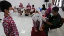 Petugas kesehatan menyuntikkan vaksin COVID-19 kepada siswa di SDN 02 Ciater, Tangerang Selatan, Selasa (14/12/2021). Mulai Hari ini, 11 provinsi di Indonesia secara serentak melaksanakan vaksinasi COVID-19 dengan sasaran anak berusia 6 hingga 11 tahun. (merdeka.com/Arie Basuki)