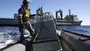 Seorang tentara Angkatan Laut Australia tampak menyisir lokasi dengan boat yang diduga tempat puing MH370 berada (2/4/2014) (REUTERS/Australian Defence Force).