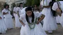 Seorang penganut kepercayaan Afro-Brasil menari saat memberi penghormatan kepada Yemenja sang Dewi Laut, ketika menyambut tahun baru di Pantai Copacabana di Rio de Janeiro (29/12/2019). (AFP/Mauro Pimentel)