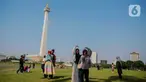 Beberapa remaja berswafoto berlatar Monumen Nasional (Monas), Jakarta, Kamis (8/2/2024). (Liputan6.com/Angga Yuniar)