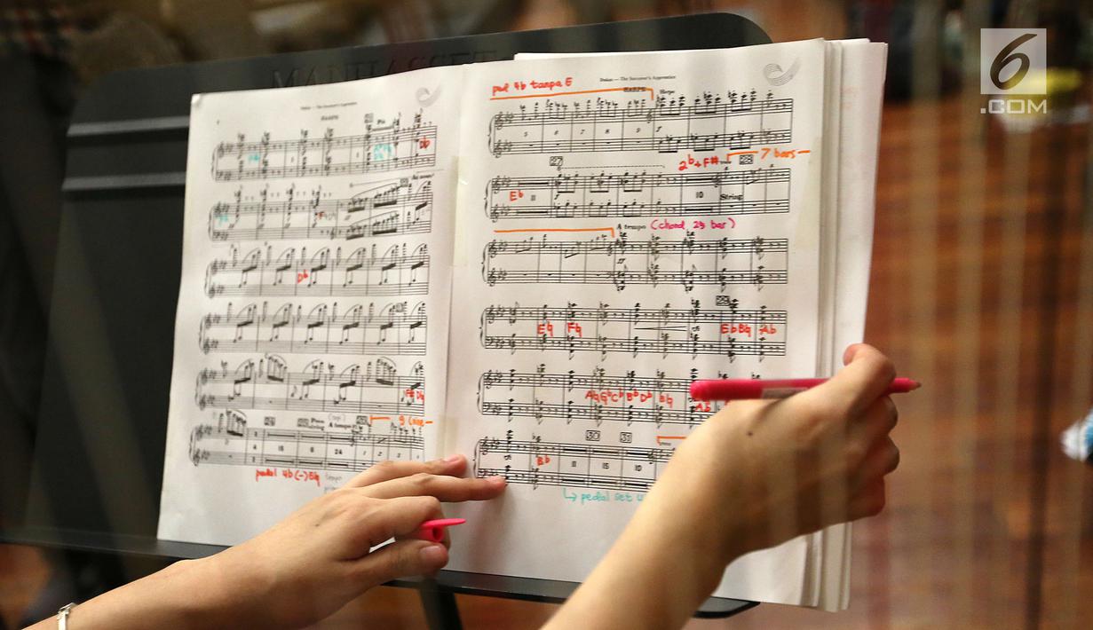 Anggota The Resonanz Music Studio melihat not musik saat berlatih jelang konser Sabda Semesta di Jakarta, Senin (25/9). The Resonanz Music Studio di bawah naungan Avip Priatna akan menggelar konsernya pada 29 September 2018. (Liputan6.com/Fery Pradolo)