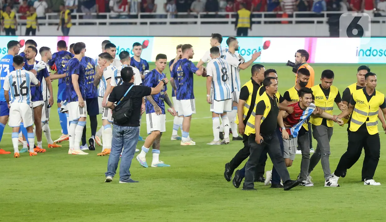 Seorang penyusup yang memakai jersey Argentina itu berhasil menembus petugas pengaman pertandingan dan berlari menuju Garnacho. (Bola.com/Muhammad Iqbal Ichsan)