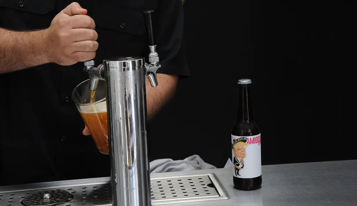 Pekerja menyajikan bir yang botolnya bergambar Presiden AS Donald Trump di perusahaan Cru Cru Brewery di Mexico City (15/6). Menurut pihak perusahan tersebut, label Trump ini menjadi kontroversial. (AFP Photo/Bernardo Montoya)