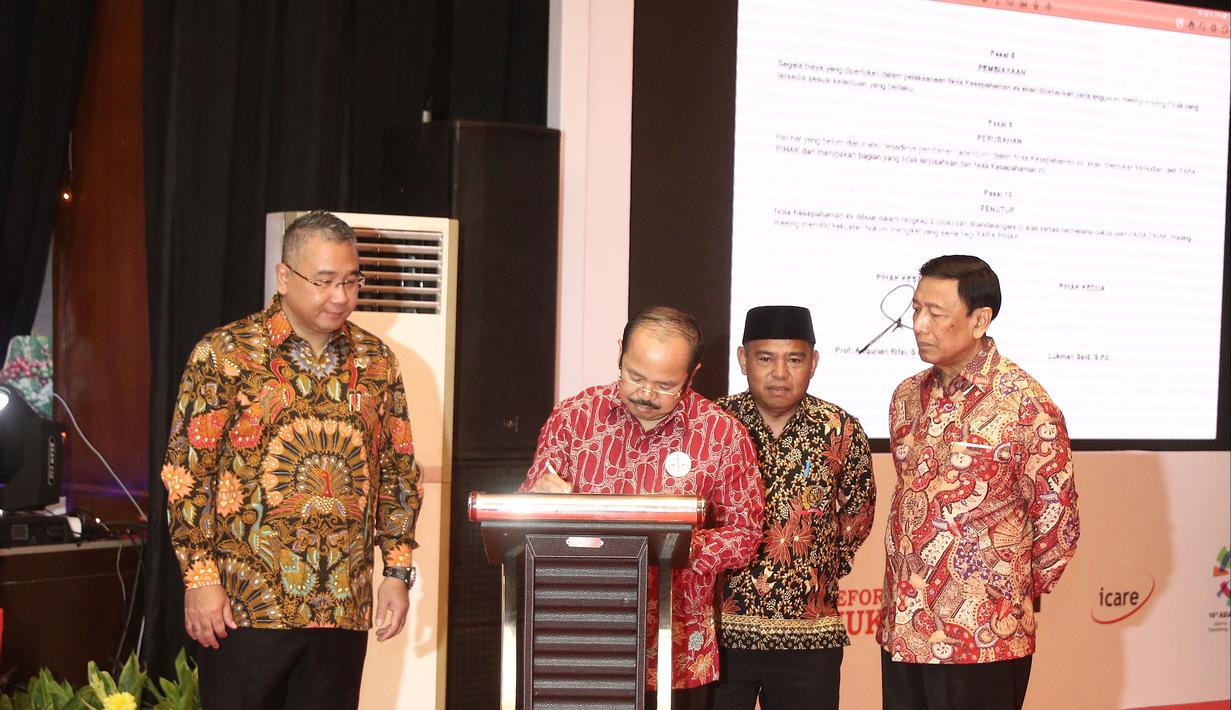 Ketua Umum Ikatan Sarjana Hukum Indonesia (ISHI) Amzulian Rifai (dua kiri) didampingi Menko Polhukam Wiranto (kanan) menandatangani MoU saat pengukuhan PP ISHI di Kemenkumham, Jakarta, Senin (30/7). (Liputan6.com/Herman Zakharia)