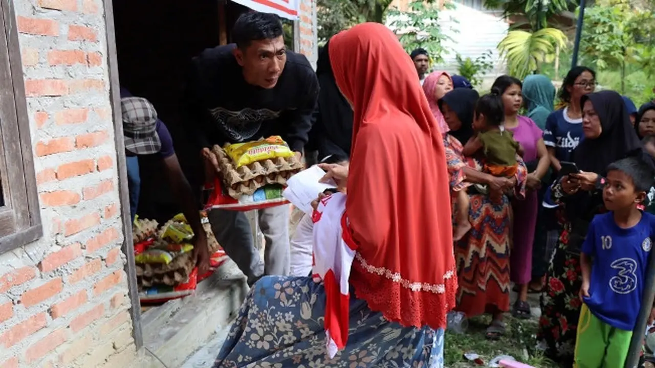 Seorang warga Pekanbaru membawa sembako dari pasar murah yang diadakan Sekretaris Jenderal Partai Solidaritas Indonesia Raja Juli Antoni.