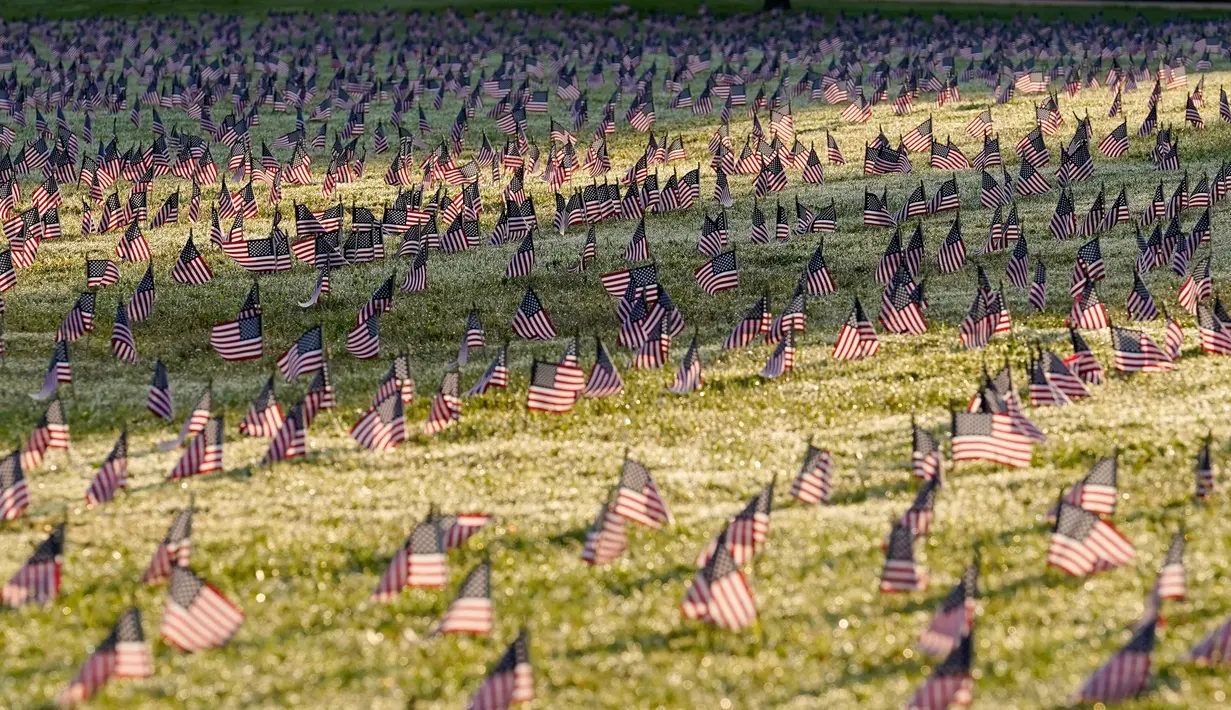 Aktivis dari COVID Memorial Project meletakkan ribuan bendera Amerika berukuran kecil di di halaman National Mall di Washington, Selasa (22/9/2020). Ribuan bendera itu menandai 200 ribu nyawa yang hilang akibat virus corona Covid-19 di Amerika Serikat. (AP Photo/J. Scott Applewhite)