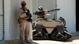 Tentara AS berdiri disamping Multi-Utilitas Tactical Transport (MUTT) saat latihan militer Rim Pasifik (RIMPAC) 2016 di Camp Pendleton, AS (13/7). Alat yang digunakan untuk patroli militer ini mempunyai teknologi canggih. (REUTERS / Mike Blake)