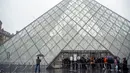 Turis berdiri di luar museum Louvre di Paris, Prancis pada Minggu (1/3/2020). Louvre, museum yang paling banyak dikunjungi di dunia, ditutup sementara untuk pengunjung setelah para staf menolak bekerja di tengah kekhawatiran terjangkit virus corona tipe baru, Covid-19. (AP/Rafael Yaghobzadeh)