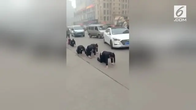 Sekelompok karyawan dihukum dengan cara merangkak di pinggir jalan kota Zaozhuang, China. Hukuman ini karena para karyawan gagal memenuhi target yang telah ditentukan.