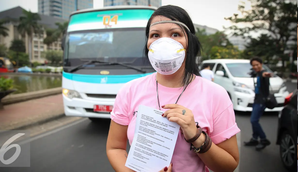 Seorang artis mengunakan masker saat aksi solidaritas #melawanasap di Patung Kuda kawasan Merdeka Barat, Jakarta, Jumat (9/10/2015). Aksi mendesak agar pemerintah segera bertanggung jawabnya untuk menanggulangi kebakaran. (Liputan6.com/Faizal Fanani)
