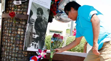 Seorang pria meletakkan karangan bunga di lokasi untuk mengenang kematian petinju legendaris Muhammad Ali, di Phoenix, Arizona, AS, Sabtu (4/6). Muhammad Ali meninggal pada usai 74 tahun setelah mendapatkan perawatan di RS. (REUTERS/Ricardo Arduengo)