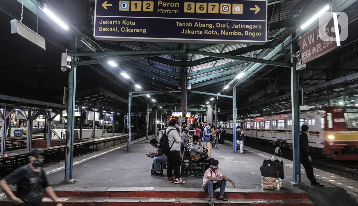 Penumpang menunggu kedatangan KRL di Stasiun Manggarai, Jakarta, Selasa (12/1/2021). Selama PSBB di DKI mulai 11-25 Januari, PT Kereta Commuter Indonesia (KCI) memangkas jadwal operasional KRL menjadi pukul 04.00 WIB hingga 22.00 WIB guna menekan penularan Covid-19. (merdeka.com/Iqbal Nugroho)