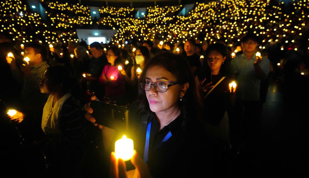 Diiringi lagu-lagu pujian yang penuh sukacita, rangkaian kebaktian Malam Natal ini berlangsung khidmat. Tampak dalam foto, orang-orang memegang lilin elektrik selama kebaktian Malam Natal di Indonesia Arena, Kompleks Gelora Bung Karno, Jakarta, Rabu 24 Desember 2025. (AP Photo/Tatan Syuflana)
