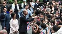 Pangeran William dari Inggris menyapa orang-orang di sebelah Menteri Senior Negara Urusan Luar Negeri Singapura Sim Ann (kiri) setibanya di Bandara Jewel Changi di Singapura pada 5 November 2023. (ROSLAN RAHMAN / AFP)