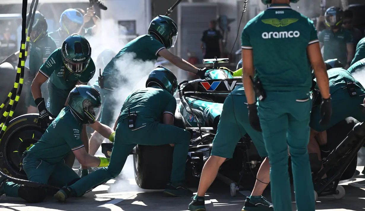 Para mekanik berlatih pit stop dengan mobil pembalap Aston Martin asal Kanada, Lance Stroll di Shanghai pada 18 April 2024. (GREG BAKER/AFP)
