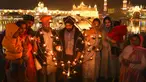 Umat Sikh menyalakan lampu tanah di Kuil Emas yang diterangi pada peringatan kelahiran Guru Nanak di Amritsar, India, 19 November 2021. Guru Nanak adalah Guru Sikh pertama dan pendiri Sikhisme. (AP Photo/Prabhjot Gill)