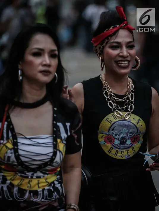 Penonton wanita berjalan untuk menyaksikan Konser Guns N’ Roses di Stadion Gelora Bung Karno, Jakarta, Kamis (8/11). Konser Guns N Roses bertajuk "Not In This Lifetime" ini akan berlangsung sekitar tiga jam. (Liputan6.com/Faizal Fanani)