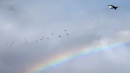 Pesawat IL-76 mengeluarkan para pasukan terjun payung saat muncul pelangi dalam latihan gabungan militer Serbia dengan Rusia yang bernama Slavic Brotherhood di kota Kovin, dekat Belgrade, Serbia (7/11). (Reuters/Marko Djurica)