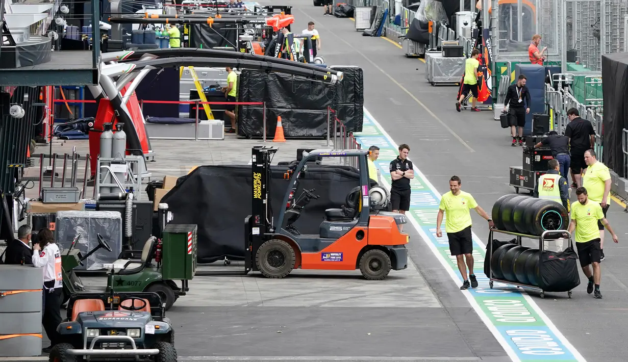 Para pekerja berkemas di pit lane setelah pembatalan Formula 1 Australia di Melbourne, Jumat (13/3/2020). Mclaren menarik diri dari balapan F1 Australia setelah salah satu stafnya positif terjangkit virus corona COVID-19. (Michael Dodge/AAP Image via AP)