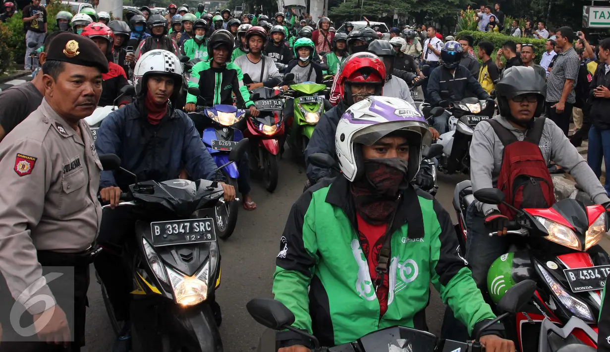 Pengemudi Ojek Online melakukan aksi sweeping terhadap taksi di kawasan Kuningan, Jakarta, Selasa (22/3). Sebuah taksi mengalami kerusakan akibat aksi anarkis dari sejumlah orang. (Liputan6.com/Helmi Afandi)