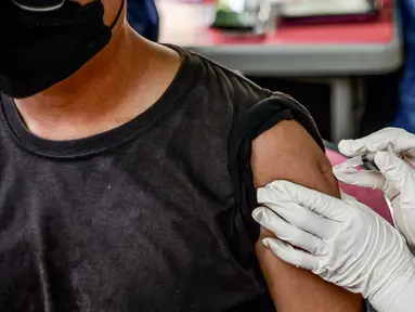 Seorang petugas kesehatan menyuntikan vaksin Inavac untuk Covid-19 di kantor dinas kesehatan provinsi Jakarta pada 19 Desember 2023. (BAY ISMOYO/AFP)