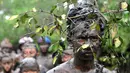 Warga Bali mengunakan akar pohon di kepalanya saat mengikuti tradisi mandi lumpur atau dikenal Mebuug-buugan di desa Kedonganan, Denpasar, Bali (10/3). Mebuug-buugan diadakan sehari usai hari raya Nyepi. (AFP/Sonny Tumbelaka)