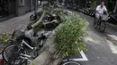 Warga melewati pohon yang tumbang dan menimpa sepeda motor akibat diterjang Topan Dujuan di Taipei, Taiwan, Selasa (29/9/2015). 24 orang mengalami cedera akibat topan raksasa Dujuan. (REUTERS/Pichi Chuang)