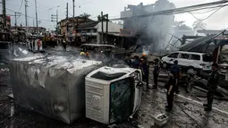 Sebuah truk terbalik akibat ledakan dahsyat yang dipicu dari api di salah satu toko kembang api di wilayah Bocaue, 30 km dari Ibu Kota Filipina, Rabu (12/10). Kebakaran itu menyebabkan dua orang tewas dengan 24 orang lainnya luka-luka. (Noel Celis/AFP)