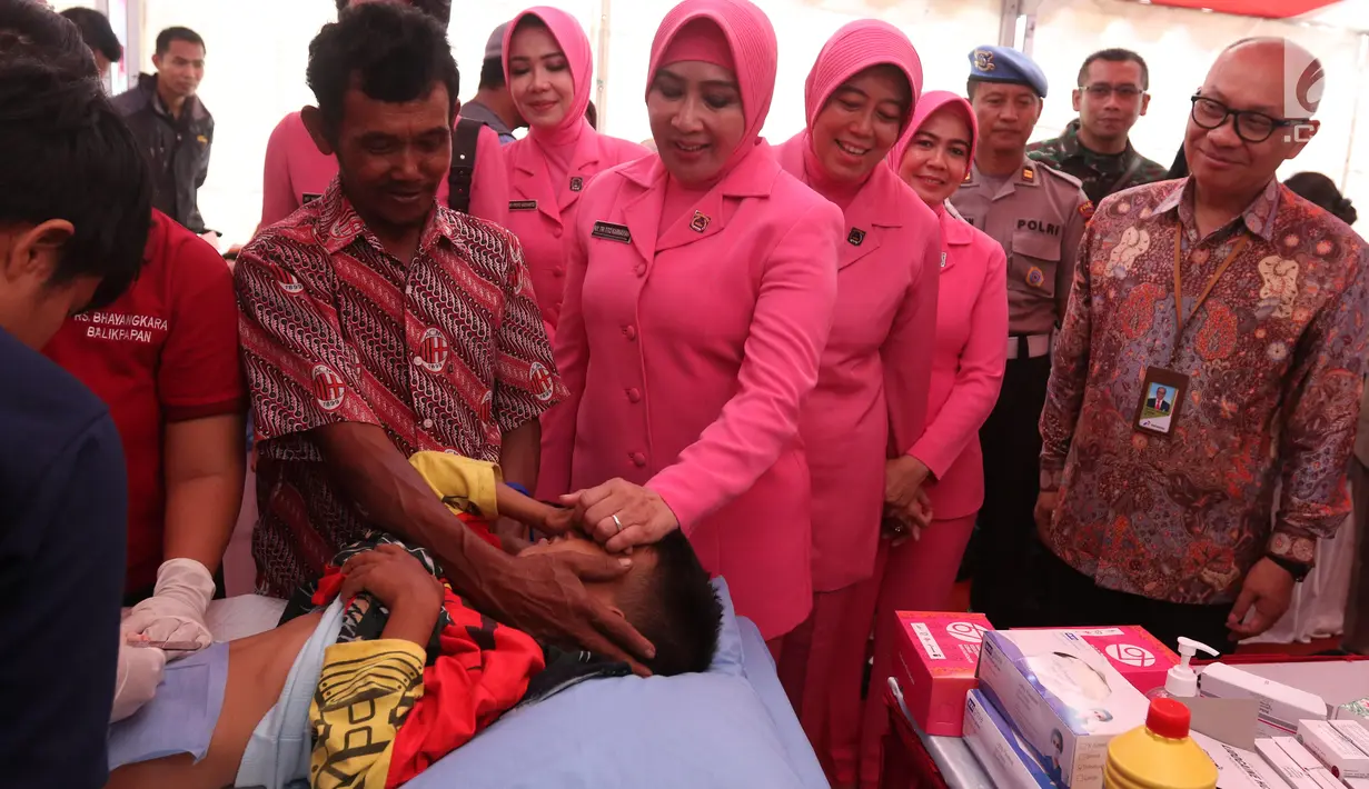Ketua Umum Bhayangkari Tri Tito Karnavian (kedua kiri) bersama Direktur Megaproyek Pengolahan dan Petrokimia Pertamina Ignatius Tallulembang (berbaju batik) berinteraksi dengan warga dalam bakti sosial di Lapangan Merdeka, Balikpapan, Kalimantan Timur, Selasa (23/7/2019). (Liputan6 com/Angga Yuniar)