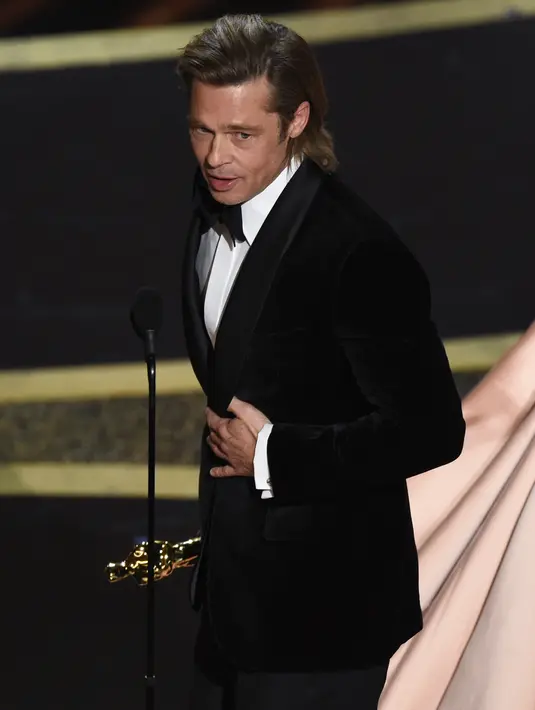 Brad Pitt menerima piala Oscar di atas panggung ajang Academy Awards ke-92 yang digelar di Dolby Theatre, Los Angeles, Minggu (9/2/2020). Brad Pitt menyabet penghargaan sebagai Aktor Pendukung Terbaik untuk aktingnya di film Once Upon a Time in Hollywood . (AP/Chris Pizzello)