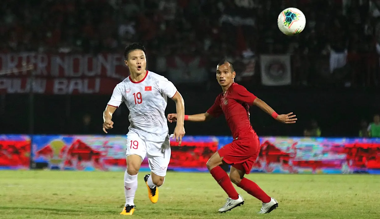 Gelandang Timnas Indonesia, Riko Simanjuntak, berebut bola dengan gelandang Vietnam, Nguyen Quang Hai, pada laga Kualifikasi Piala Dunia 2022 di Stadion Kapten I Wayan Dipta, Bali, Selasa (15/10). Indonesia kalah 1-3 dari Vietnam. (AFP/Aditya Wany)
