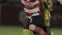 Gelandang Madura United, Nuriddin Davronov, berebut bola dengan striker Bhayangkara FC, Herman Dzumafo, pada laga Liga 1 di Stadion PTIK, Jakarta, Kamis, (07/6/2018). Bhayangkara FC menang 1-0 atas Madura United. (Bola.com/M Iqbal Ichsan)
