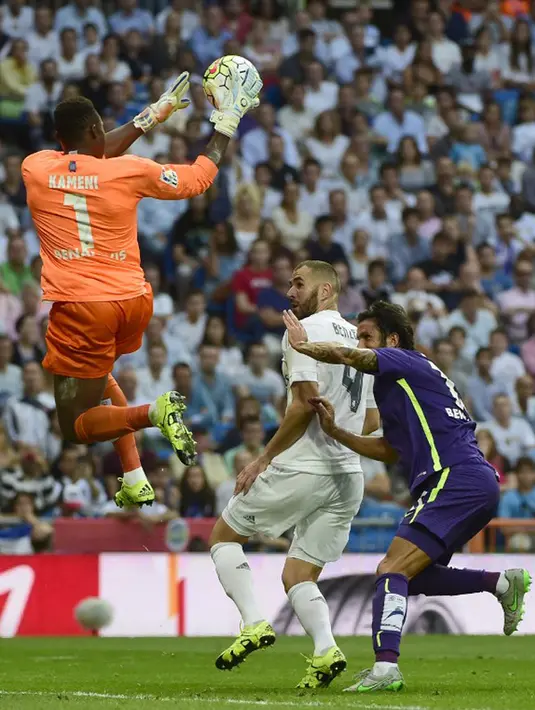 Kiper Malaga, Idriss Kameni (kiri) berusaha menangkap bola dari kejaran penyerang Karim Benzema pada Liga Spanyol di Santiago Bernabeu, Madrid, (26/9/2015). Madrid bermain imbang atas malaga dengan skor 0-0. (AFP PHOTO/PIERRE-PHILIPPE Marcou)