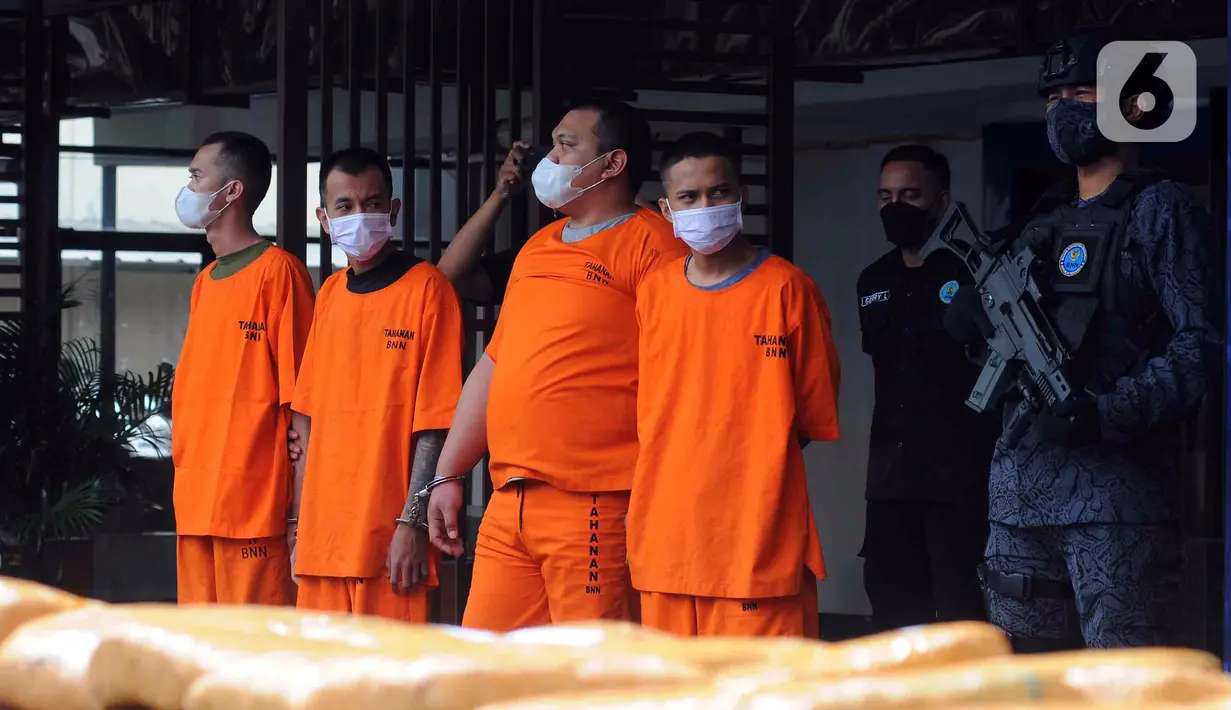 Tersangka dihadirkan saat pemusnahan barang bukti ganja di Lapangan Gedung BNN, Jakarta, Rabu (18/1/2023). BNN memusnahkan barang bukti 222,697 kilogram ganja dan menangkap empat tersangka berinisial AE alias Adul, RJ, MF, dan G yang merupakan narapidana Lapas Kelas I Tangerang dari pengiriman paket kargo di depan Mall Cijantung. (merdeka.com/Imam Buhori)
