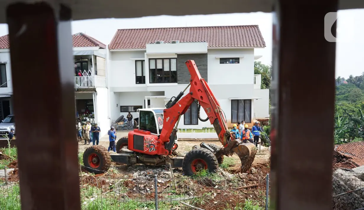 Petugas menggunakan alat berat berusaha merapikan posisi turap yang hancur di Jalan Damai, Ciganjur, Jakarta Selatan, Minggu (11/10/2020). Banjir sekaligus longsor tersebut mengakibatkan dua orang luka-luka dan satu orang meninggal dunia. (Liputan6.com/Immanuel Antonius)