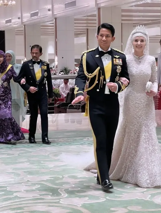 Jika biasanya Anisha Rosnah mengenakan gaun sederhana dan simple pada prosesi pernikahannya, kali ini ia tampil lebih glamor dan mewah. Ia mengenakan gaun lengan panjang putih berpayet dan rok mermaidnya. Ia membawa mini clutch yang serasi dengan gaunnya. [@missnoorcahaya]