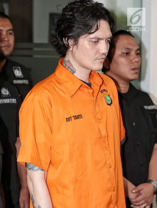 Anak musisi Ahmad Albar, Ozzy Albar dibawa petugas kepolisian seusai rilis kasus Narkoba di Polda Metro Jaya, Jakarta, Kamis (13/9). Ozzy ditangkap di sebuah ATM di Jalan Wolter Monginsidi dengan barang bukti ganja 2,66 gram. (Liputan6.com/Faizal Fanani)