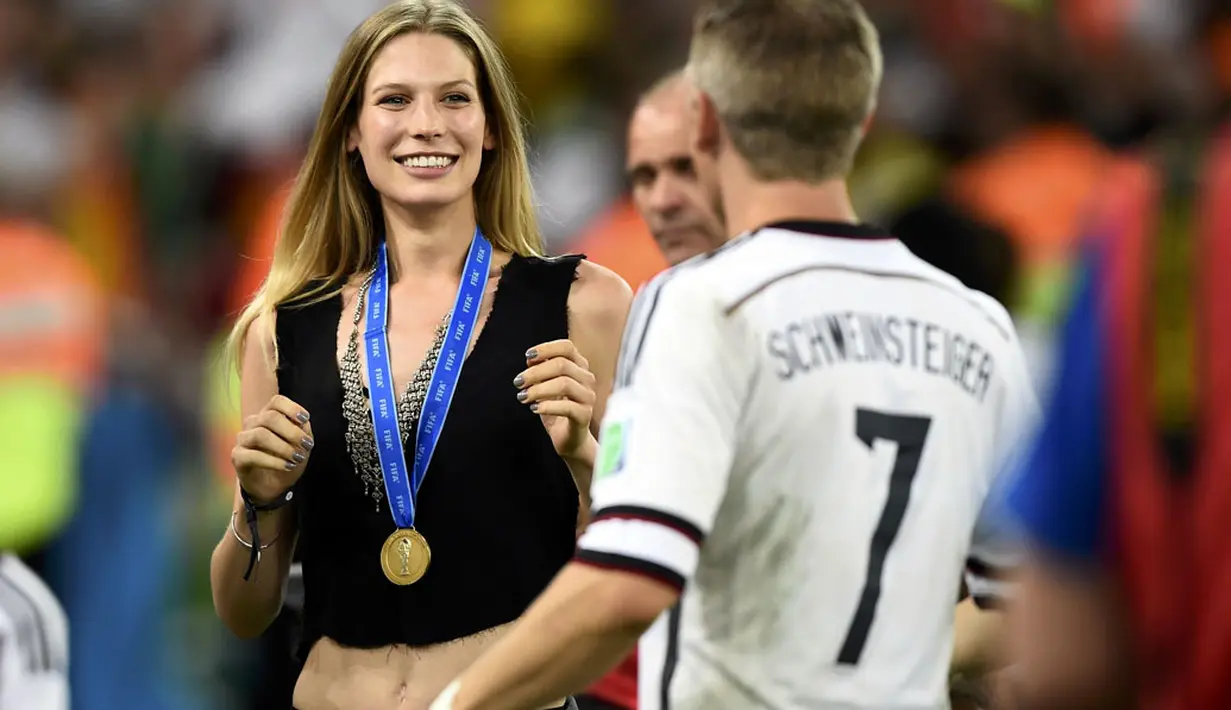 Pemain tengah Timnas Jerman, Bastian Schweinsteiger (kanan), menghampiri kekasihnya, Sarah Brandner, disela-sela selebrasi juara Piala Dunia 2014, Brasil, (14/7/2014). (REUTERS/Dylan Martinez)