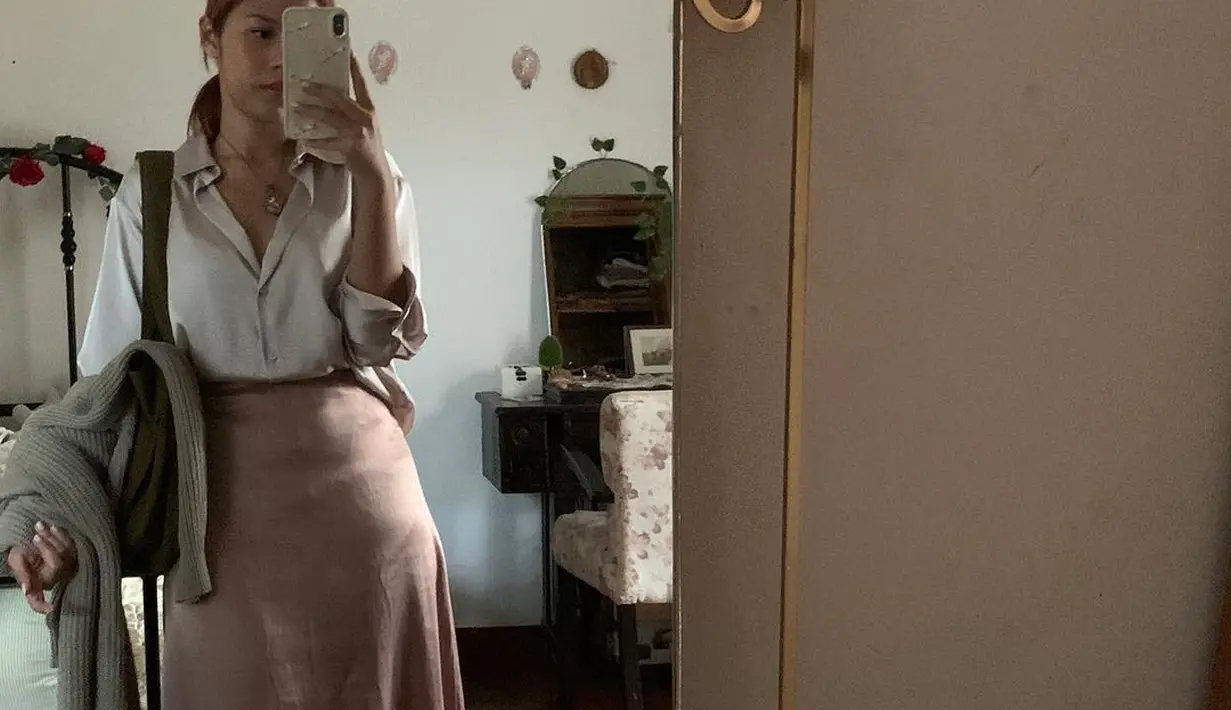 Outfit Nadin Amizah yang satu ini bisa kamu pakai untuk ngantor. Memadukan kemeja satin dengan rok panjang [@cakecaine]