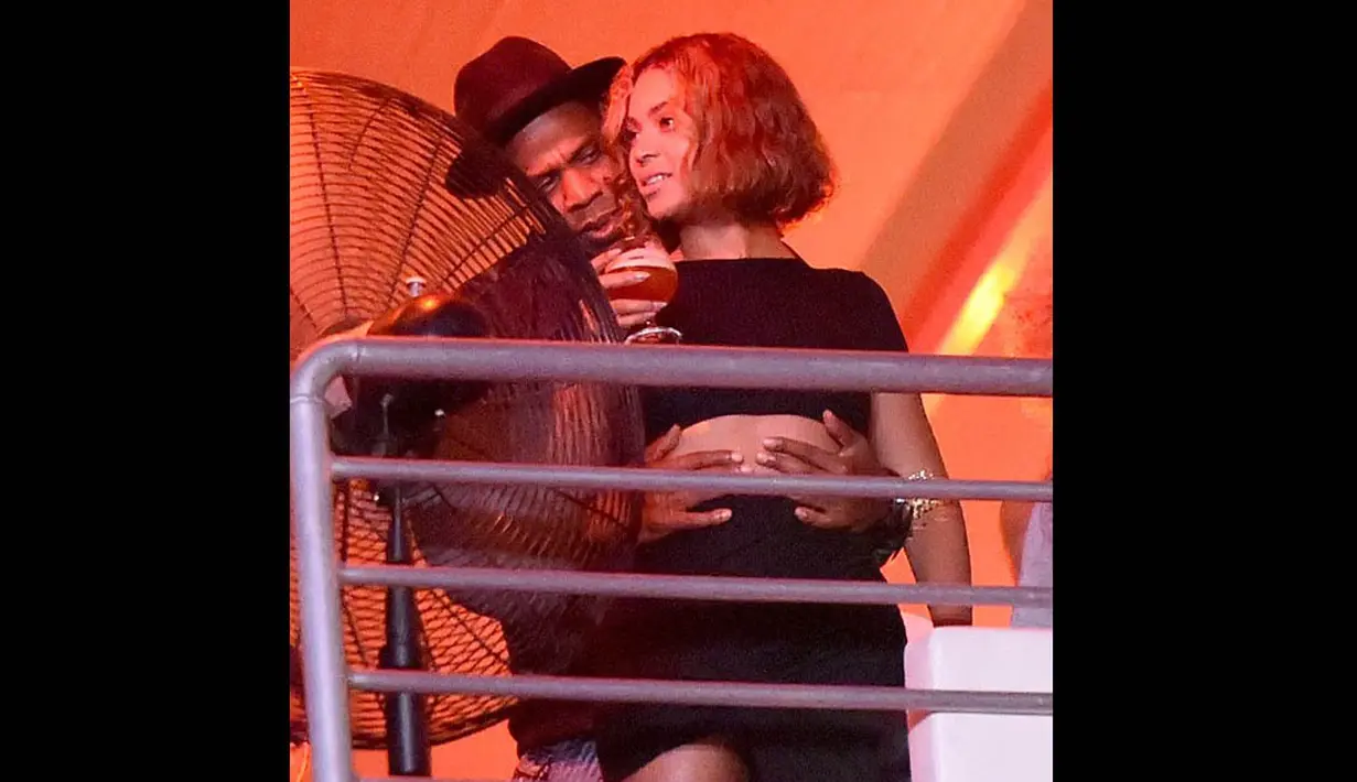 Sang rapper tampak melingkarkan lengannya di pinggang sang istri, Beyonce, yang sedang menggenggam minuman, Senin (1/9/14). (Dailymail)