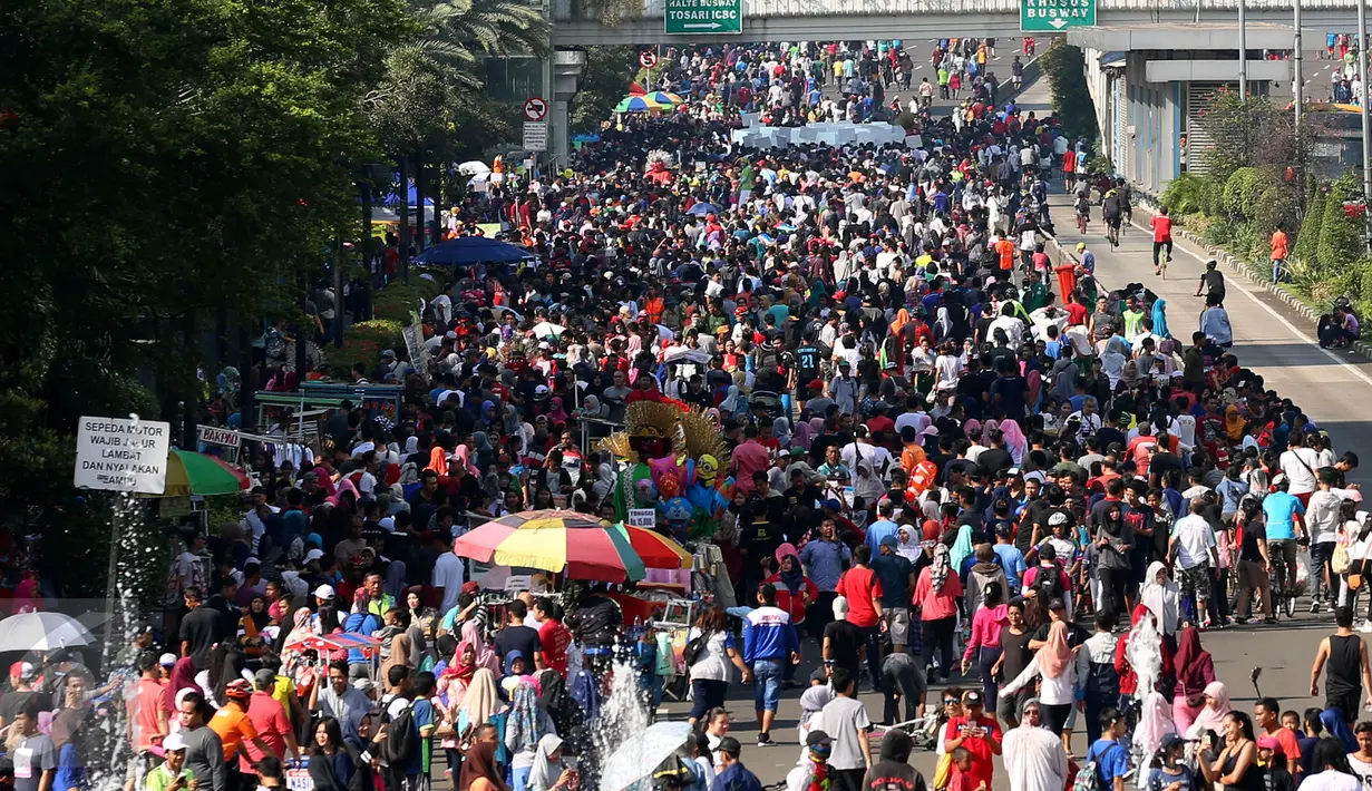 Sejumlah orang memadati kawasan Sudirman saat Car Free Day, Jakarta, Minggu (30/4). Warga memanfaatkan liburan panjang dengan mengunjungi CFD bersama keluarga atau teman. (Liputan6.com/Johan Tallo)