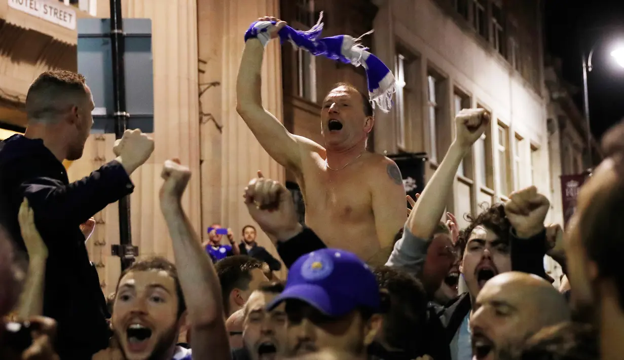 Sejumlah suporter Leicester City berteriak usai timnya berhasil meraih juara Liga Inggris di depan rumah Jamie Vardy, Leicester, (3/5). Leicester Juara setelah saingannya Tottenham bermain imbang 2-2 dengan Chelsea. (Reuters/Eddie Keogh)