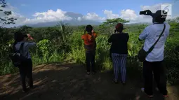 Warga memantau aktifitas Gunung Agung di Pos Pemantauan Desa Rendang, Karangasem, Bali, Jumat (29/9). Pusat Vulkanologi dan Mitigasi Bencana Geologi mencatat aktifitas Gunung Agung masih tetap tinggi. (Liputan6.com/Gempur M Surya)