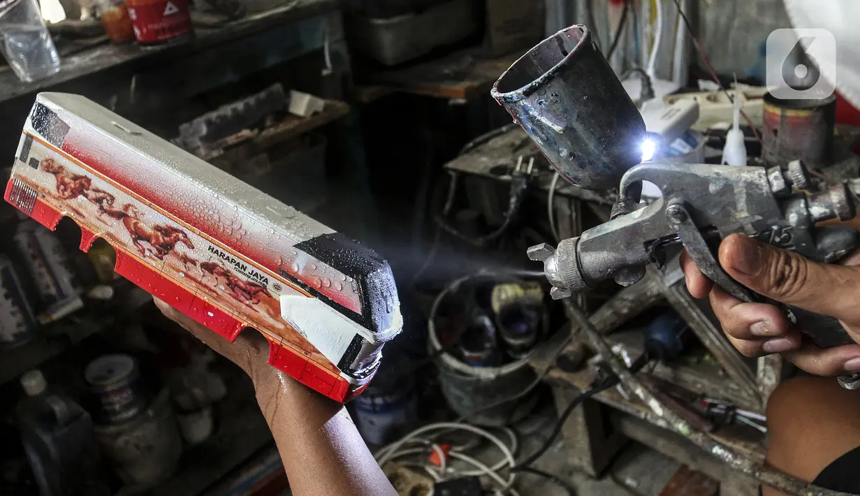 Perajin menyelesaikan pembuatan miniatur bus di Workshop Belang Bentong, Limo, Depok, Jawa Barat, Jumat (14/1/2022). Kerajinan miniatur bus berbahan baku akrilik dan resin tersebut dipasarkan ke berbagai daerah dengan harga Rp 700 ribu hingga Rp 1 juta per unit. (Liputan6.com/Johan Tallo)